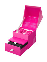 We-Vibe Chorus gaveeske åpnet i perspektiv, med øvre rom for vibrator og fjernkontroll og nedre uttrekksskuff med svart ladedokking.