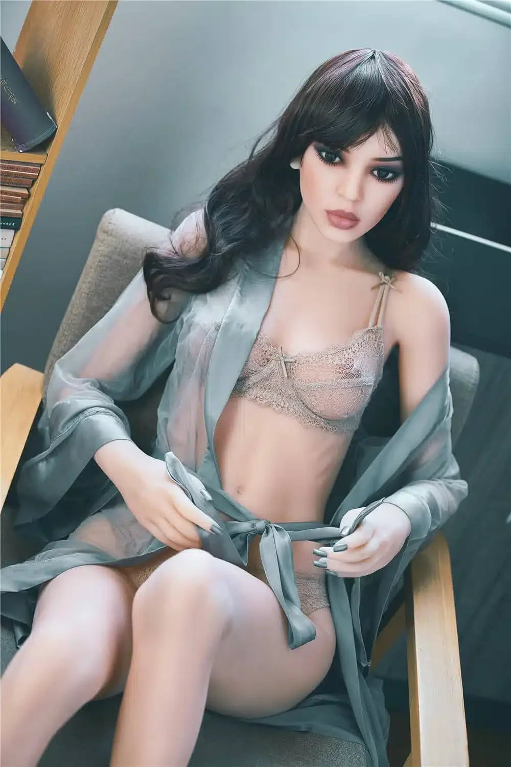 Realistic silicone doll in lace lingerie and silk robe seated in an armchair