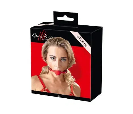 Product box showing a woman wearing a red silicone ball gag, adult toy packaging.