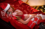 Realistic love doll in red lingerie and Santa hat, lying on red blanket with Christmas gifts