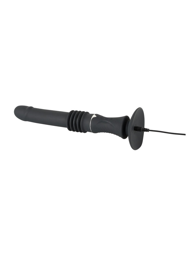You2Toys portabel sexmaskin liggende horisontalt, med sugekoppen vendt mot kamera. Ladekabel er koblet til porten på baksiden.