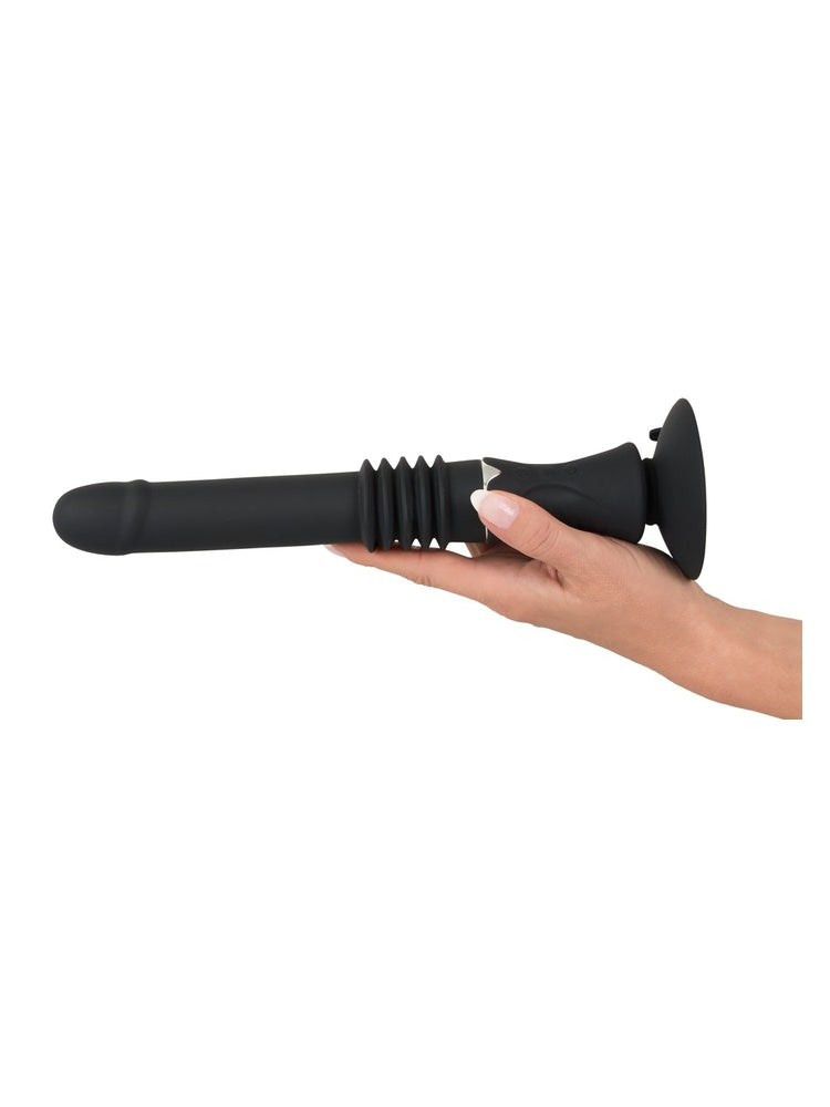 Hånd holder You2Toys portabel sexmaskin horisontalt i håndtaket. Viser størrelsesforhold og ergonomisk grep under bruk.