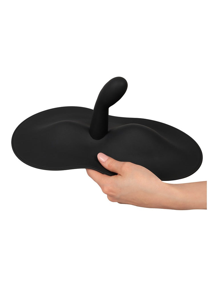 Hånd som holder Vibepad 3 og viser fleksibiliteten i den myke silikonbasen.