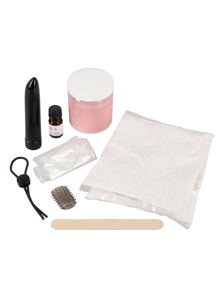 Cloneboy Vibro kit – allt innehåll utlagt: svart vibrator-enhet, rosa silikongummi i burk, härdningsvätska i liten flaska, gjutform i plastpåse, stor silikonpulse-påse, penisring, stimulerande gummiärm och träspatel mot vit bakgrund.